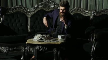 Amerikan para işi. Zengin beyefendi para sayar. Karanlık odada para sayan bir gangster. Zengin iş adamı. Takım elbiseli zengin adam banknotları sayıyor. Çok parası olan zengin bir adam.