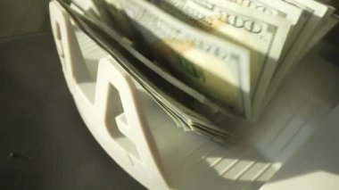 Kapatma para sayma makinesi dolar sayıyor. Ağır para sayma makinesi 100 dolarlık banknotları sayıyor. Para sayma makinesi. Finans bankacılığı kredi mevduat nakit