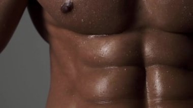 Yakın plan seksi üstsüz, üstsüz genç adam. Yakışıklı kaslı adam. Formda seksi erkek modelin seksi vücudu. Mükemmel kaslı vücudu olan bir güzellik adamı. Seksi, çıplak, genç, orta doğulu adam kaslı vücudunun tadını çıkarıyor.