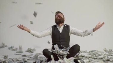 Zengin adam. Takım elbiseli bir işadamı, neredeyse sonbaharda para yağdıracak. Zengin İşadamı dolar banknotları içinde oturuyor. Nakit parası olan zengin bir adam. Dolar olarak çok parası olan zengin bir adam.