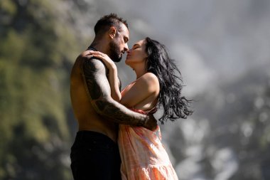 Şehvetli çift doğaya tutkuyla sarılıyordu. Doğayı öpen çiftler. Yaz doğasına aşık romantik çift. Seksi ve şehvetli bir çiftin açık hava portresi. Şefkatli öpücük ve tutkulu dokunuş