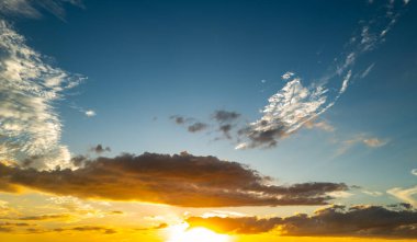 Gündoğumu gökyüzü arka planı. Dramatik gün batımı. Gökyüzü bulutlu ve arka planda gökyüzü aydınlığı var. Farklı şekillerde bulutlarla gün doğumu. Sakin gündoğumu gökyüzü ve bulutlar arasından güneş.