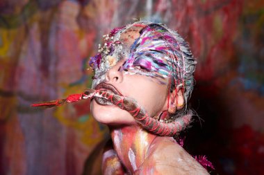 Vücut sanatı. Yüz rengi tasarımı. Renkli güzel kadın yüzü. Yaratıcı sanat makyajlı güzel bir manken. Yaratıcı vücut sanatı ve saç modeli. Boyalı kadın. Çekici kadın yüz sanatı