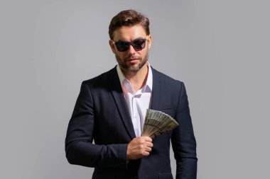 Dolar banknotları olan bir adam. Bir sürü 100 dolarlık banknot tutan bir iş adamı. Kolay para. Kara para. Ödeme günü ve ödeme konsepti. Kâr ve zenginlik. Para kazan. İş adamı başarılı anlaşma