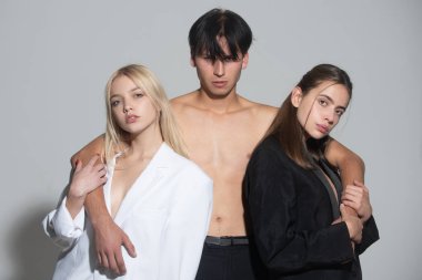 Poliyamory ve çok eşlilik. Üçlü erkek ve iki seksi kadın. Üçlü 'nün romantik ilişkileri. Bir grup seksi model. Moda insanları. Aşk ve romantizm. Çok eşlilik, eş değiştirme. Arkadaşlar seksi