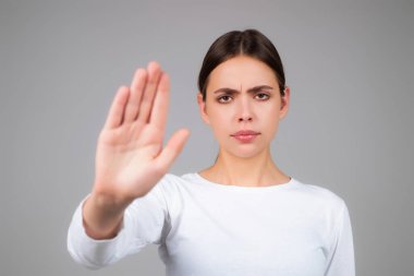 Dur hareketi yapan kadın. Avuç içiyle dur işareti yapan genç bir kadın. Bir elini uzatan genç bir kadının portresi, tabu işaretini durdur, reddet, reddet. Dur işareti yapan kız