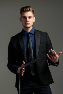 İş adamı kravat bağlar. Smokin ya da resmi takım elbise için Boyunbağı. Kravatlar ve fiyonklar. İş adamı kostümü. Kravatlı bir erkek model. Klas takım elbiseli genç adam kravat ayarlıyor. Moda görünüşü.