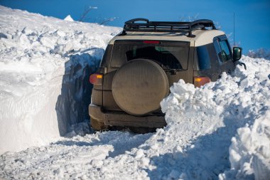 Kış lastikleri. Dağlarda karlı yollarda. Kar altında off-road aracı. Ormanda bir arazi aracı, karda sürükleniyor. Kar fırtınasında off-road arazi aracı. Arabalar off-road gezisi, kış off-road pisti