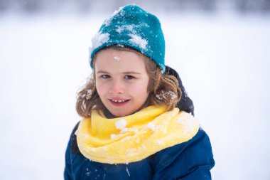 Çocuklar karda yüzükoyun yatıyor. Mutlu Çocuk Kartopu 'yla oynuyor. Kışlık giysili çocuk karla oynuyor. Kış çocukları karla oynar. Karda sevimli bir çocuğun portresi. Kış çocuğu suratı. Çocuk kartopu oynuyor.