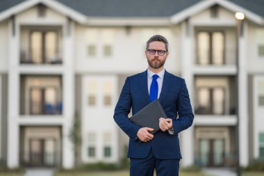 Emlakçı, takım elbiseli bir iş adamı, dışarıda not defteri tutuyor. İspanyol iş adamı. İş adamı komisyoncusu ya da emlakçı. Takım elbiseli bir iş adamı. Emlakçı.