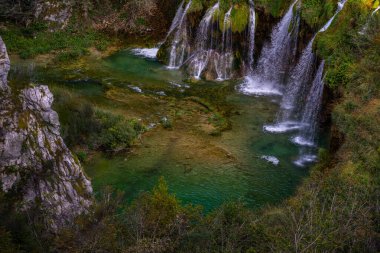 Plitvice Lakes Ulusal Parkı. Hırvatistan. Büyük şelaleler. Doğa yolculuğu geçmişi. Güzel yaz doğası. Hırvatistan 'daki Plitvice şelaleleri. Ormanın derinliklerindeki göl. Turkuaz Gölleri