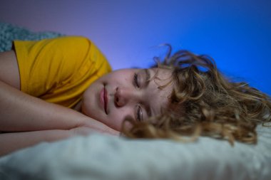 Çocuk yatakta uyuyor. Çocuklar için yastık ve battaniye. Küçük çocuk uyuyor. Küçük çocuk yatakta uyuyor. Uyuyan çocuk. Çocuk karanlık bir odada uyuyor. Evdeki bir yatakta uyuyan çocuk