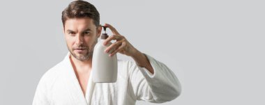 Cilt bakımı. İzole edilmiş stüdyo afişi. Erkekler için organik kozmetik. Güzellik uzmanı cilt bakım ürünlerini sunar. Sabun şişesi, cilt için jöle köpüğü. Doğal insan cilt bakımı için kozmetik tutuyor.