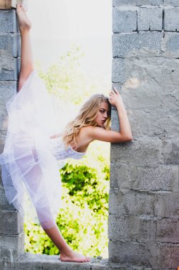 Bacak ayıran, esnek kız ayrılıyor. Kadın dışarıda egzersiz yapıyor.