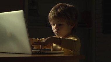 Bilgisayarlı bebek. Evde dizüstü bilgisayarla çalışan sarışın bir bebek. Akıllı küçük çocuk dizüstü bilgisayarını kullanıyor. Sevimli bebek bilgisayarı. Bilgisayardaki küçük kız. Bir dizüstü bilgisayarın önünde bebek şaşırmış ifadesi