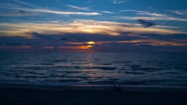 Mavi ve turuncu dramatik gökyüzünde güneş ve bulutlarla gün batımı. Gökyüzü gün batımı zamanı. Akşam gökyüzü, gün batımı kırmızı, turuncu, sarı güneş ışığı ile bulutlar koyu mavi alacakaranlıkta altın gün batımından sonra