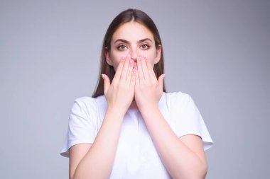 Girl raising eyebrows being surprised and shocked. Astonished reaction on unexpected news. Girl in t-shirt on isolated studio background with shocked, surprise and amazed expression on face