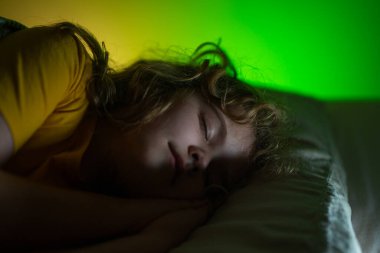 Çocuk yatakta uyuyor. Çocuklar için yastık ve battaniye. Küçük çocuk uyuyor. Küçük çocuk yatakta uyuyor. Uyuyan çocuk. Çocuk karanlık bir odada uyuyor. Evdeki bir yatakta uyuyan çocuk