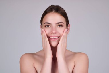 Güzel kadın yüzü, cilt bakımı, doğal makyaj. Genç modelin güzel yüzü. Güzel bir kızın portresi stüdyo arka planında güzellik tedavisinden zevk alıyor. Güzel doğal kız.