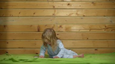 Heyecanlı pijamalı bebek gülüyor ve eve yatağa atlıyor. Çocukluk, günaydın. Bebek yatakta zıplıyor, evde eğleniyor. Çocuk zıplayarak ve yatakta oynayarak eğleniyor. Yatak odasında bebek oyunu