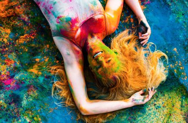 Mutlu kız bayramı kutluyor Holi. Yaratıcı vücut sanatı ve saç modeli olan genç bir kadın.