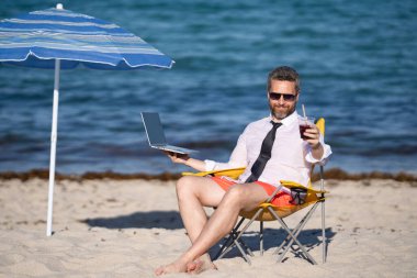 Uzaktan kumandalı yazlık deniz plajında çalışıyor. Tropik plaj tatili sırasında dizüstü bilgisayarı olan bir iş adamı. Boş bir hafta sonu ve uzak bir serbest çalışma. Çılgın komedyen deniz sahilinde dinleniyor.