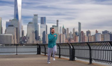 Koşun! Sağlıklı Adam New York 'ta koşuyor. Fitness sporu, adam koşucusu Manhattan yakınlarında koşuyor. Amerikan caddesinde koşan adam. Spor kıyafetlerle New York 'ta koşan bir adam. Olgun koşucular için spor kıyafeti