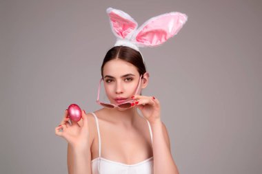 Easter bunny girl wear easter fluffy bunny ears hold easter eggs, isolated studio background. Eater portrait of female bunny