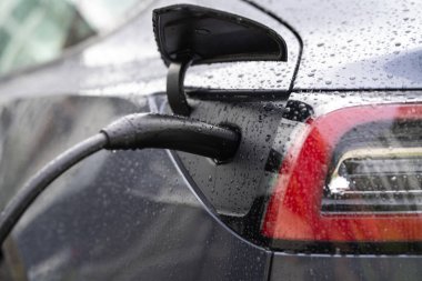 Kablolu elektrikli araba şarjı. Şarj istasyonunda elektrikli araba. Elektrikli motoru olan bir araç için fiş. EV şarj aleti. Temiz enerji. Otoparkın şarj noktası. Elektrikli araba şarj istasyonu