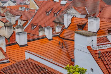 Evin arka planındaki ahmaklar. Çatı deseni. Çatı arkaplanı. Seramik kiremitlerle kaplı bir çatı. Çatı kiremit kaplama bina. Kasabadaki eski bir evin çatısı yıpranmış. Çatı fayansları
