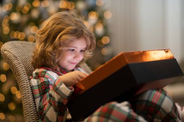 Noel 'i kutlayan küçük bir çocuk ya da evde Noel ağacı olan bir çocuk.