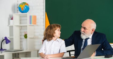 Öğretmen ve çocuk sınıfta. Eğitim konsepti. Okul öğrenme konsepti. Erkek ilkokulu. Yaşlı ve Genç