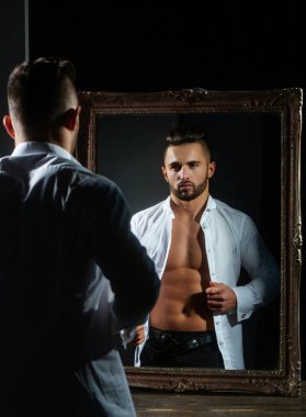 Çıplak ve güçlü bir adam karın kaslarını gösteriyor. Kaslı üstsüz bir adam. Seksi erkek vücudu. Yakışıklı seksi model. Gömleksiz, kaslı erkek model. Çıplak gövdeli bir adam. Mükemmel kaslı vücut.