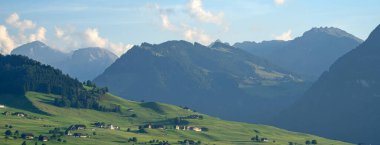 Dağlar ve ağaç arka planı. Dağlar manzaralı. Alp çayırları ve güzel dağlar. Orman geçmişi. Yeşil dağ manzarası. Dağın panoramik manzarası. Doğa arkaplanı