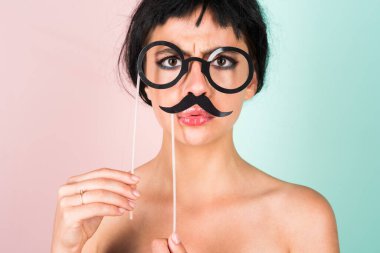 Young woman in black wig looking making fake mustache positive and happy. Funny Girl smile. Young transgender woman. Funny woman face. Portrait of attractive funny girl grimacing. Emotion woman clipart