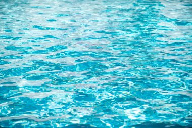 Su arka planı, dalgalanma dalgaları. Mavi yüzme havuzu deseni. Deniz yüzeyi. Yüzme havuzunda su ve güneş yansıması. Kopyalama alanı olan pankart