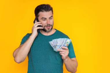 Paralı bir adam. Dolar banknotları. Elinde bir deste para tutan adamın portresi. Dolar, kredi, internet bankacılığı. Dolar banknotlarını, banka kredisini, mali tasarrufları gösteren zengin bir adam.