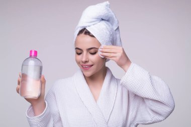 Pamuk ped kullanan bir kadın. Pamuk yastıkla cildi temizleyen güzel bir kız. Yüz toneri ya da temizleyici süt. Makyaj kaldırılıyor. Pamuk pedlerle yüzünü temizliyor. Makyaj malzemelerini temizlemek için losyon