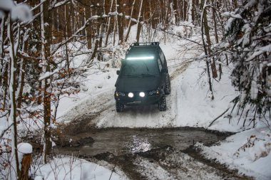 Dağlarda karlı yollarda. Kış karında off-road aracı. Kış ormanlarında yol dışı araç, karda sürüklenmek. Kar fırtınasında off-road arazi aracı. Arabalar off-road gezisi, kış off-road pisti