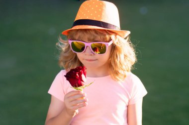 Çocuk sevgisi. Çocuk Sevgisi. Moda Şapkalı Güzel Çocuk Rose 'u tut. Sevgililer günü çocukları. Rüya gören çocuğun portresi. Çocuklar rüya görüyor. Tatlı aşk çocukları rüyaları. Hayalperest romantik çocuk kokusu.
