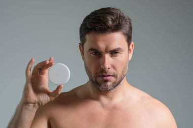 Kozmetik kremi olan adam. Erkek kaplıca modeli cilt bakım kremi ürünü uyguluyor. Sabah kremi, kaldırma ve yaşlanma önleyici kırışıklık etkisi. Cilt bakımı. Mükemmel yumuşak ciltli bir adam. Güzellik ürünleri.