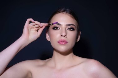 Woman shaping brown eyebrows. Woman eye with beautiful eyebrows. Shaped brows, long eyelashes. Paint eyebrows. Girl contouring eyebrows on isolated studio background