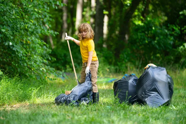 Küresel çevre kirliliği. Çocuk dışarıda plastik çöp topluyor. Çevre koruma kavramı. Çocuk çöp torbasına atık koyuyor. Eko çocuklar gönüllü. Çevre kirliliği