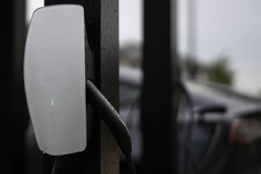 Elektrikli araba şarj istasyonuna bağlandı. Elektrikli araba şarj oluyor. EV araba ve ev şarj istasyonu kavramı. Şarj edilebilir EV. Şarj için elektrikli arabaya güç kaynağı bağlanıyor.