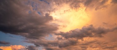 Günbatımı arka planı. Dramatik görkemli gün batımı. Gökyüzü bulutlu ve gökyüzü aydınlık arka planda. Farklı şekillerde bulutlarla gün doğumu. Sakin gün batımı gökyüzü ve bulutlar arasında güneş