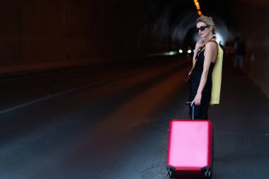 Moda elbisesi içinde bavullu gezgin bir kadın. Seyahat ve macera. Seyahat çantalı seksi kız tatile çıkmaya hazır.