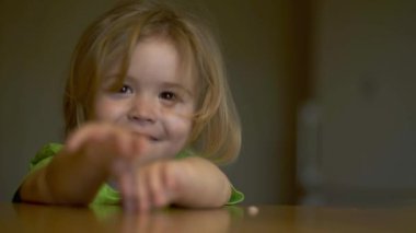 Bebek kaşıkla yiyor. Çocuk yemeğini ye. Çocuk maması yiyen aç küçük bir çocuk. Bebek yulaf lapası. Küçük bebek sağlıklı yiyecekler yiyor. Küçük bir bebek yemeğini yiyor. Komik çocuklar yüz ifadeleri