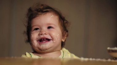 Sevimli bir bebek kaşıkla yemek yer. Çocuk maması yiyen aç küçük bir çocuk. Bebek yulaf lapası. Yemek zamanı. Küçük bebek sağlıklı yiyecekler yiyor. Küçük bir bebek yemeğini yiyor. Yiyeceği olan çocuğun yakın plan portresi