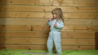 Heyecanlı pijamalı bebek gülüyor ve eve yatağa atlıyor. Çocukluk, günaydın. Bebek yatakta zıplıyor, evde eğleniyor. Çocuk zıplayarak ve yatakta oynayarak eğleniyor. Yatak odasında bebek oyunu