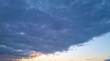 Alacakaranlık Gökyüzü zaman dilimi. Hareket eden bulutlar ve günbatımı. Bulutlar akşam boyunca yüzer. Alacakaranlık gökyüzü zaman aşımına uğradı. Dramatik gökyüzü hareket ediyor. Kümülüs ve sirrus fırtınada. Gün doğumu bulutu